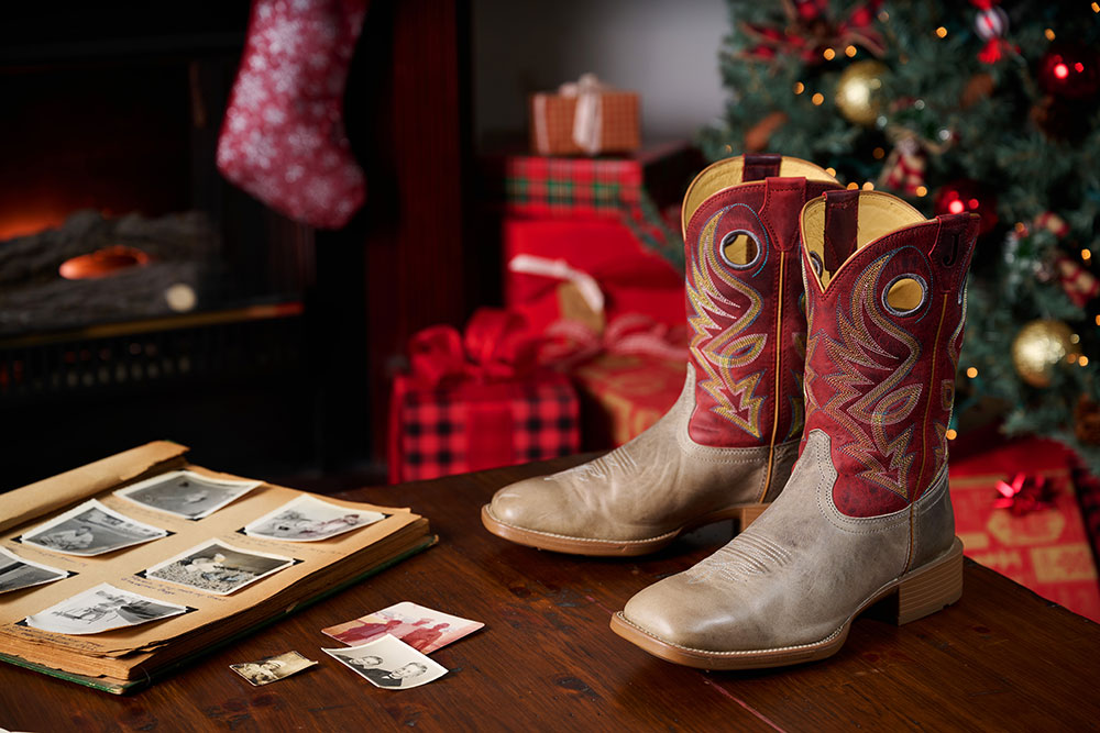 Pickett 11” Men’s Wide Square Toe in grey posed on a table with a Christmas background behind it.